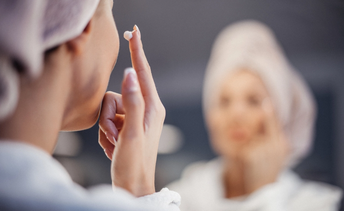 A lady putting anti-aging cream on her face